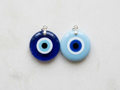 Dark blue and light blue glass Nazar pendants displayed side by side on a white background.