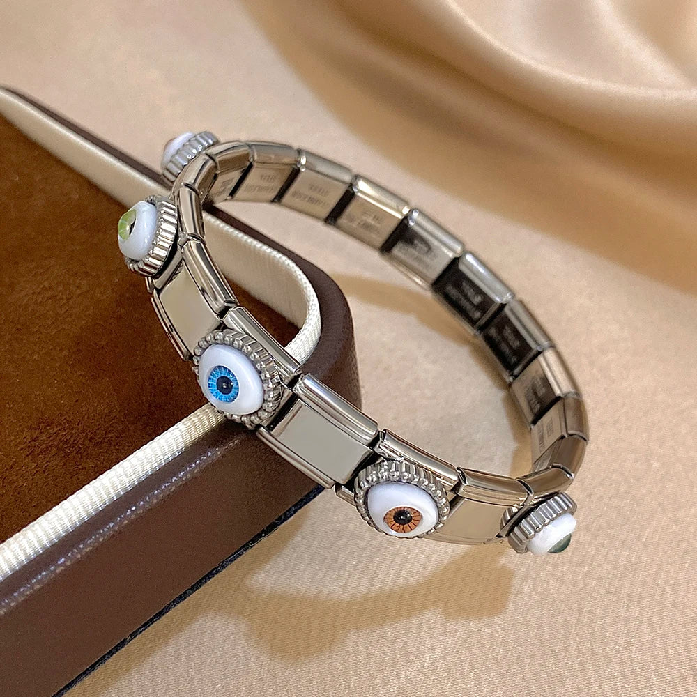 Silver bracelet with eye-shaped charms on a beige surface