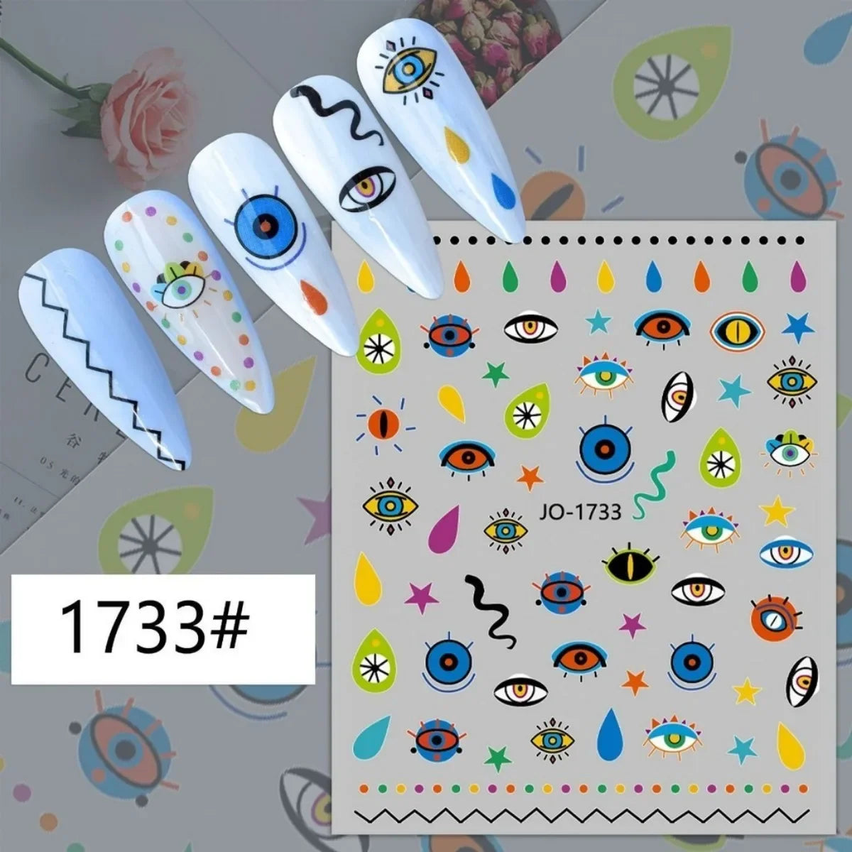 Colorful eye and abstract nail stickers displayed on white manicure samples