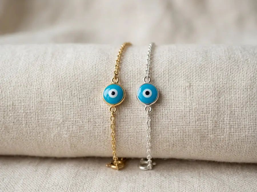 Corrected mixed-metal stack with an echoed gold tone and a repeated blue eye linking gold and silver chains