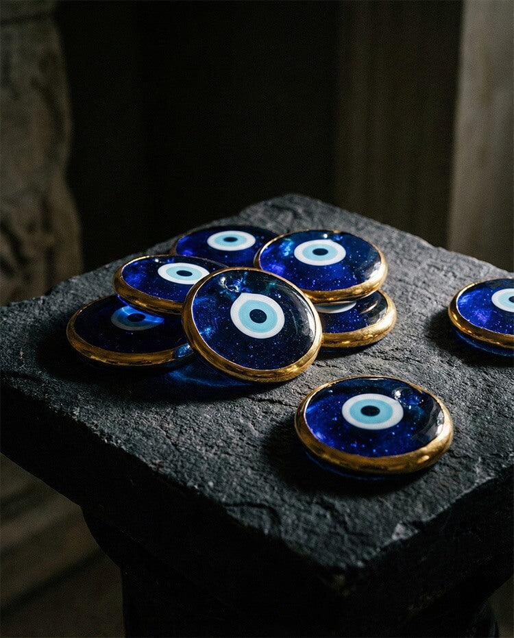 Curated collection of handcrafted blue evil eye glass amulets with golden accents