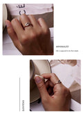 Hands wearing a 925 sterling silver adjustable evil eye ring