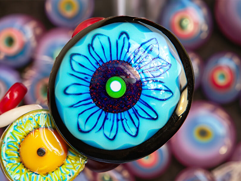 A Close-Up Shot Of A Multicolored Evil Eye Talisman With Various Colors Highlighted