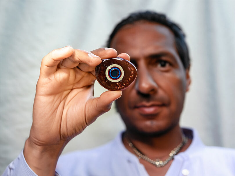 Person Holding A Brown Evil Eye Amulet