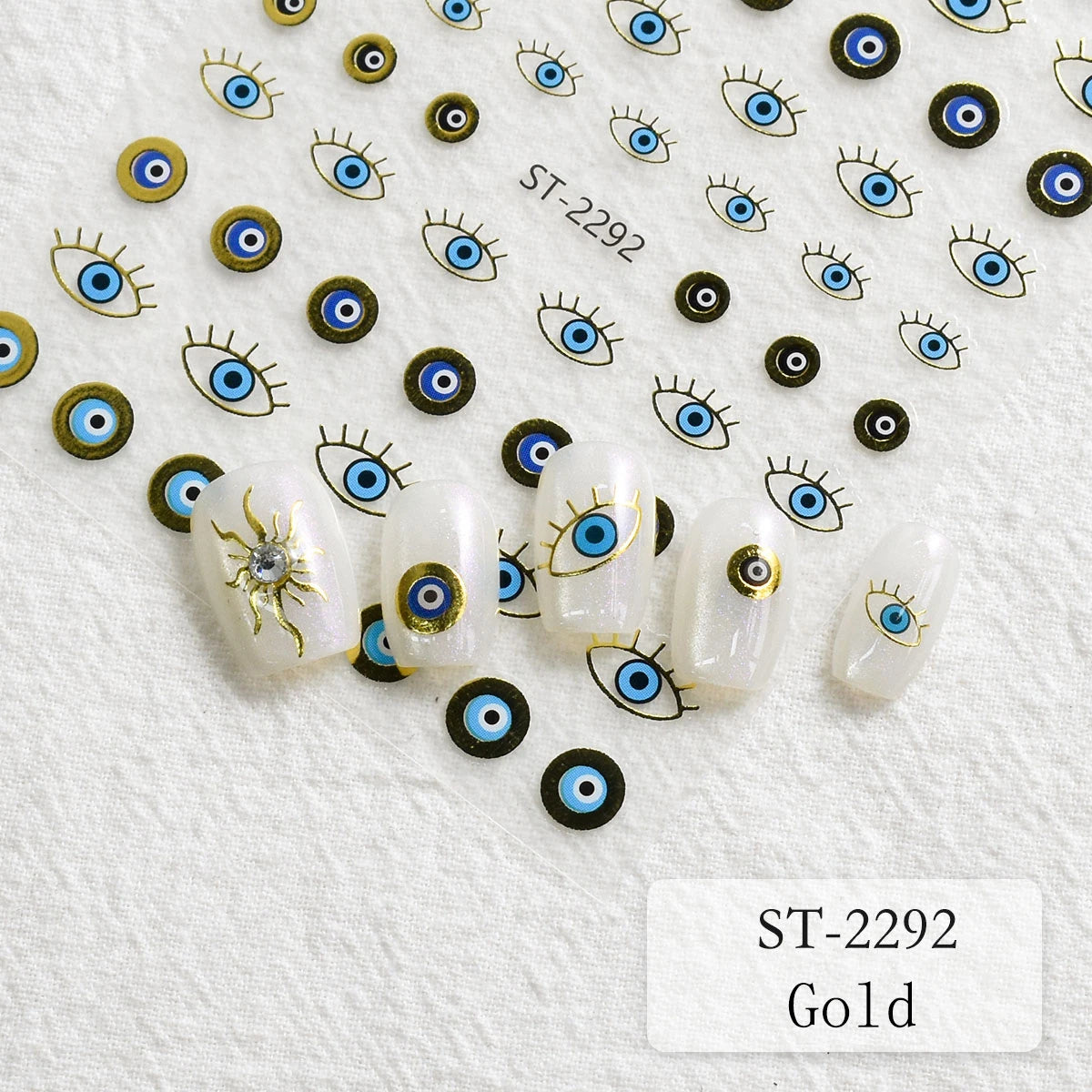 Nail art stickers featuring blue and black evil eye designs with gold outlines, shown on a textured white background with several sample nails decorated.