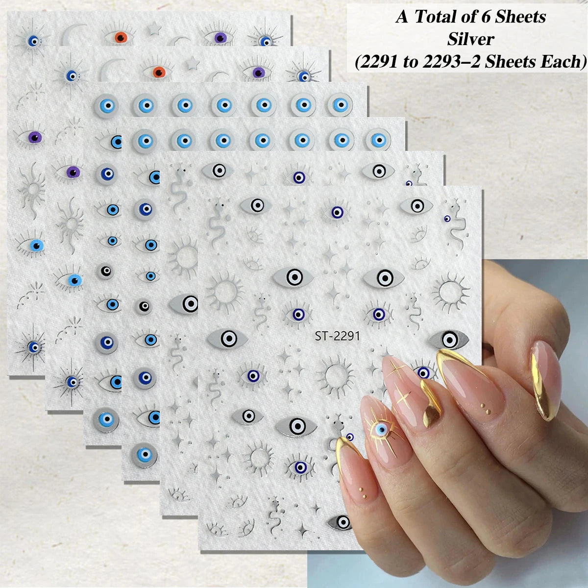 Six sheets of silver nail art stickers featuring evil eye and sun motifs, shown with a hand displaying manicured nails decorated with the stickers.