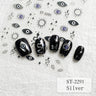 Five black nail art decals or false nail tips with silver and blue evil eye designs are arranged on a white textured background, surrounded by matching small eye, star, and wavy line motifs. Text reads ST-2291 and Silver.