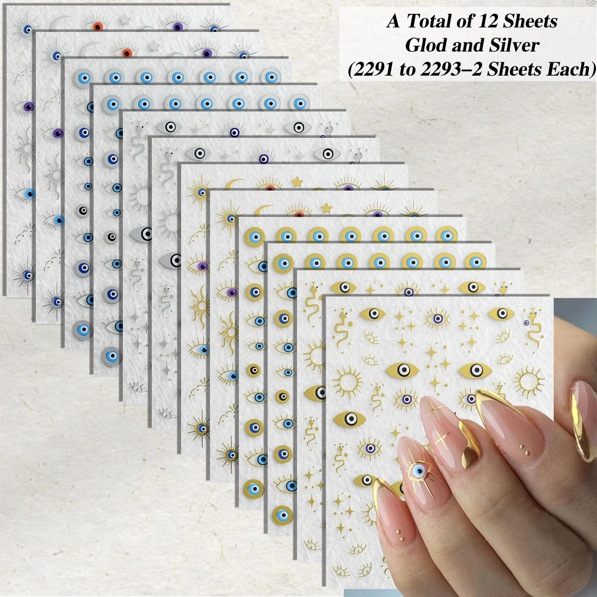 A set of 12 nail art sticker sheets featuring evil eye and sun motifs in gold, silver, blue, and black, shown fanned out next to a hand with manicured nails decorated with the stickers.