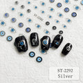 Five black nail wraps decorated with evil eye designs are arranged on a textured white background, alongside loose matching evil eye stickers and printed sample illustrations. The text 'ST-2292 Silver' appears in the bottom right corner.