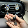 Side and rear view of a silver tone Hamsa clip showing a black mount, two projecting prongs and the patterned back of the round pendant.