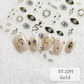 Nail art sticker sheet and applied nail examples featuring gold evil eye, snake, sun, and star motifs on a white textured background. The sheet and sample nails are labeled ST-2291, with one variant note reading Gold.
