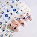 Blue and gold-tone evil eye nail stickers beside a manicure with eye, Hamsa, moon, and star motifs