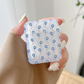 Handheld frosted earphone case patterned with small blue eye motifs along thin curved lines.