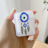 Frosted earphone case with blue circular eye artwork and three illustrated black feathers, held in one hand.