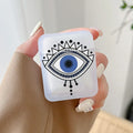 Handheld frosted earphone case with a large blue eye framed by black outlines, dots and triangular details.