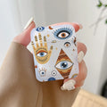Handheld earphone case with blue eyes, yellow hand artwork, orange geometric motifs, stars and a crescent.