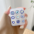 Handheld earphone case with nine varied circular eye motifs arranged in three rows, in blue, white, black and yellow.