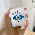 Handheld frosted earphone case with a large blue eye, black rays and a yellow arc beneath the eye.