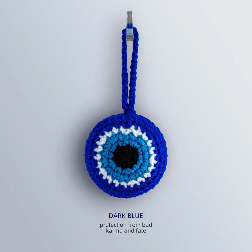 Front view of the Blue evil eye charm with a deep blue border and loop surrounding white and turquoise blue rings and a black center.