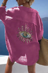 Back view of a fuchsia shirt with a large sequin eye motif and curved hem