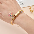 Multicolored beaded cuff bracelet with a rectangular eye centerpiece and tassel worn on a wrist