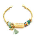 Gold tone open cuff with green beads, a lettered centerpiece, palm tree charm and green tassel