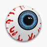 Round white button pin with a blue iris, black pupil and red vein illustrations.
