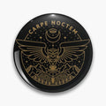 Black round button pin with gold tone Carpe Noctem lettering, an outstretched owl, mountains, stars and a crescent moon.