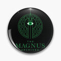 Black round button pin with green The Magnus Archives lettering and an eye within a circular architectural drawing.