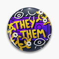 Round purple and black button pin with yellow They Them lettering, white eyes and flowers.