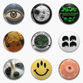 Nine round button designs including a radiating eye, green eye lettering, a raccoon, a yellow smile and a citrus eye.