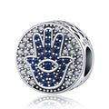 Silver tone round bead with a blue Hamsa hand, an eye in the palm and a border of clear accents