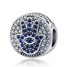 Silver tone round bead with a blue Hamsa hand, an eye in the palm and a border of clear accents