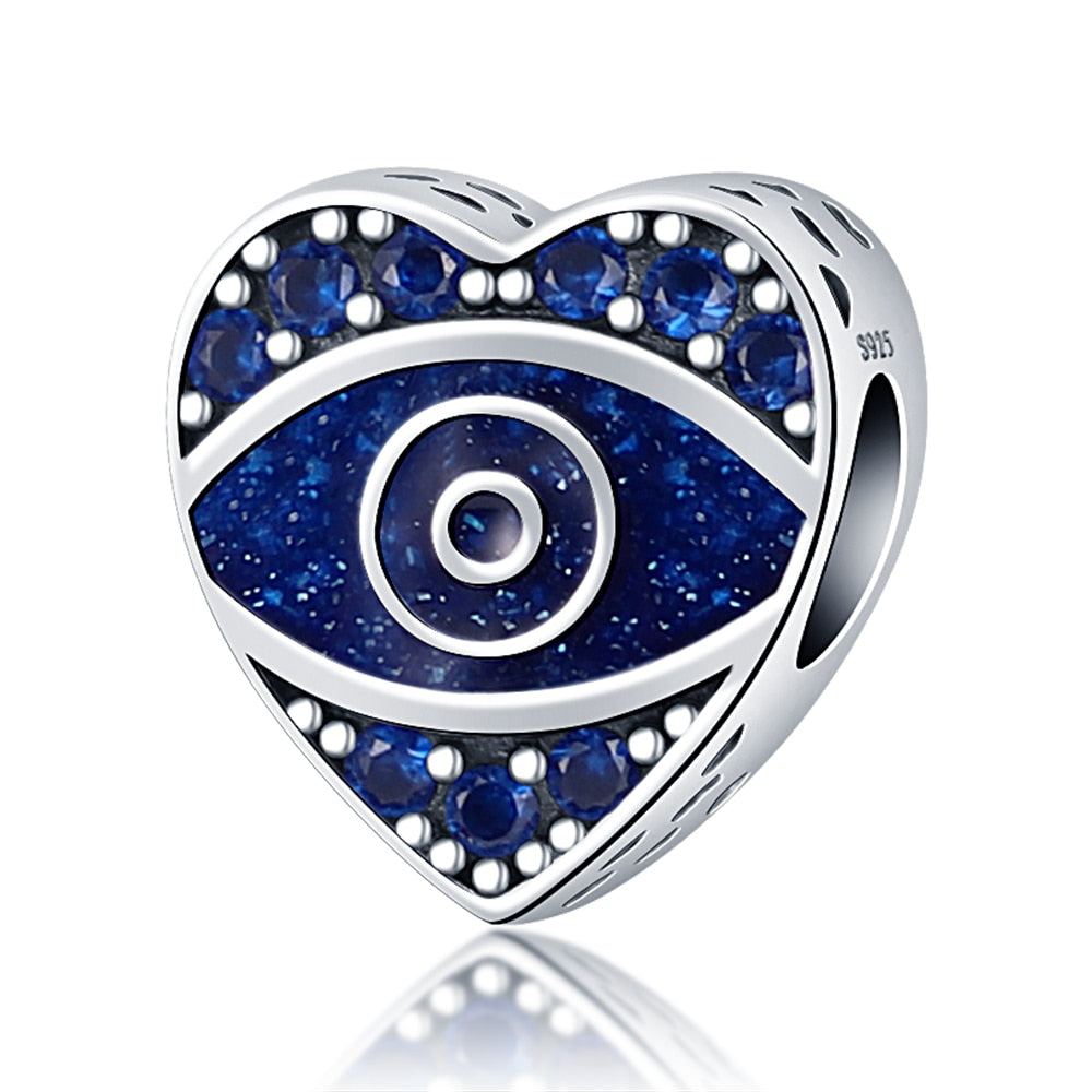 Silver tone heart bead with a speckled blue eye, blue faceted accents and a visible side opening