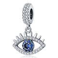 Silver tone open eye dangle with upper lashes, a blue center, clear accents and a decorated bail