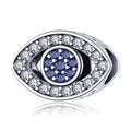 Silver tone open eye bead with a round blue center, clear border accents and a visible side opening