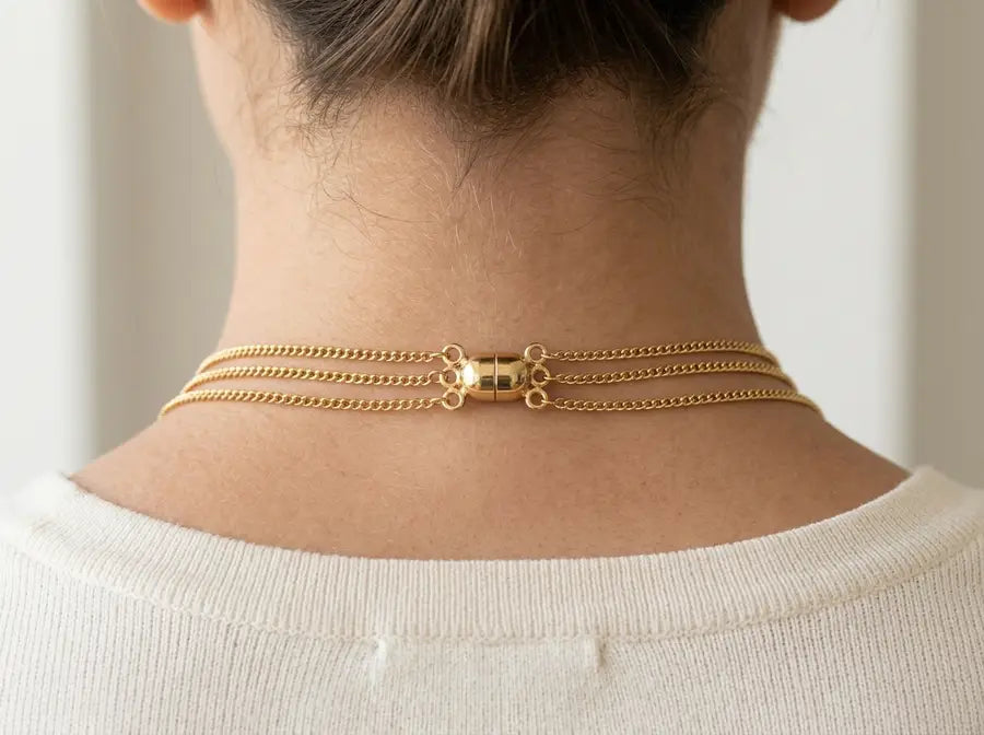 Back-of-neck view with staggered clasps and a single layering clasp keeping evil eye chains from braiding