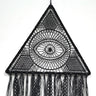Close-up of the black triangular dream catcher showing its central eye, radiating lines, mesh corners and patterned fringe.