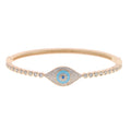 Rose gold tone evil eye bangle with a turquoise blue center and round clear accents on white