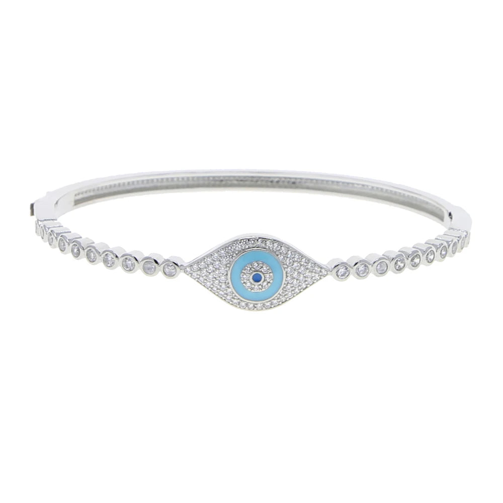 Silver tone evil eye bangle with a turquoise blue center and round clear accents on white
