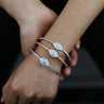 Silver tone and rose gold tone evil eye bangles stacked on one wrist