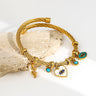 Gold tone bangle angled to show the snake, heart eye and turquoise-colored eye charms