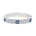 Silver tone evil eye bangle with rows of clear accents and raised blue eye discs