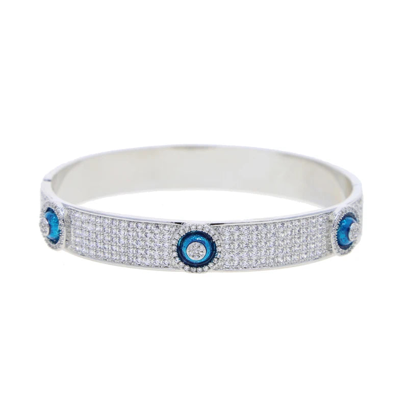 Silver tone evil eye bangle with rows of clear accents and raised blue eye discs