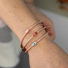 Pink, red and blue evil eye bangles shown together on a wrist
