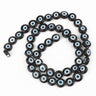 Black flat round beads with white and pale blue eye rings, arranged in a loop
