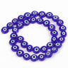Dark blue flat round beads with pale blue and white eye rings surrounding black centers
