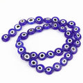 Dark blue flat round evil eye beads with white rings and black centers, arranged in a loop