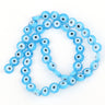 Light blue flat round beads with white and pale blue eye rings, arranged in a loop