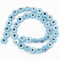 Light blue flat round beads with white eye rings and black centers, arranged in a loop